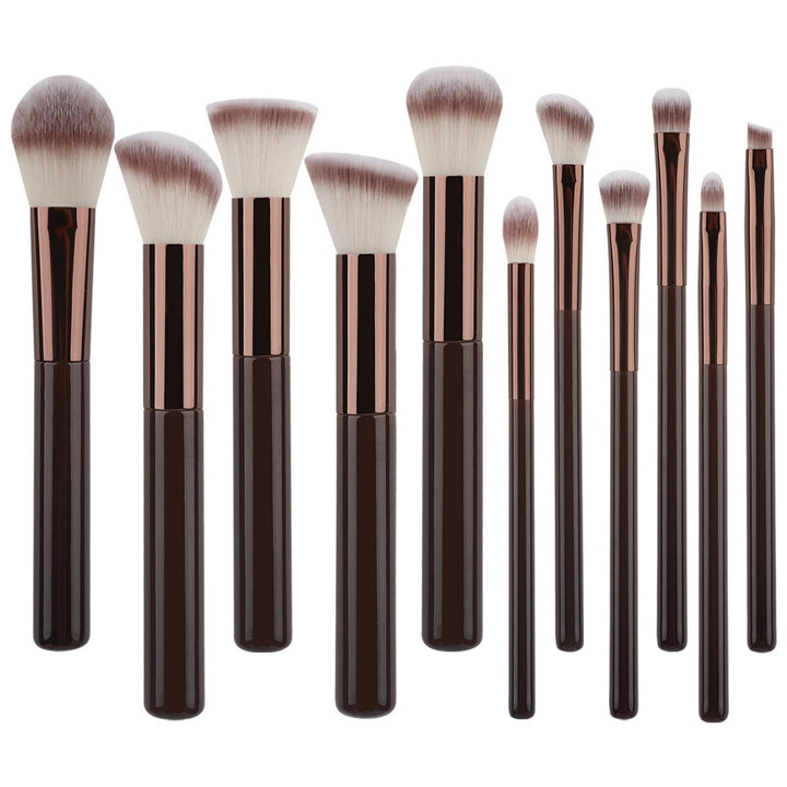 The Technique PRO Chocolate Bronze Makeup Brush Set includes 11 professional brushes with dark brown handles and rose gold ferrules, featuring various brush head shapes—such as a foundation brush—displayed upright against a white background.