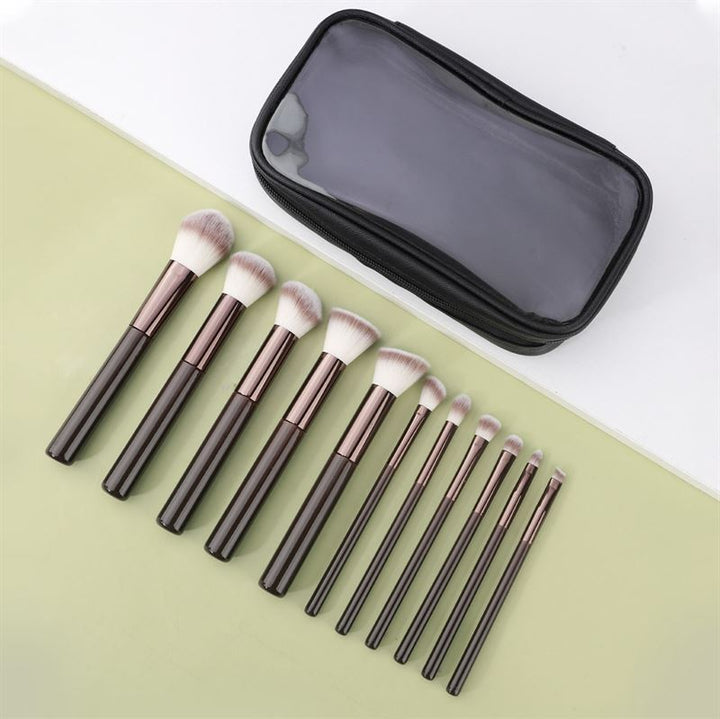 The Technique PRO Chocolate Bronze Makeup Brush Set includes 11 professional brushes with dark handles, white bristles, and a sleek black zippered case with a clear top—ideal for flawless makeup application.